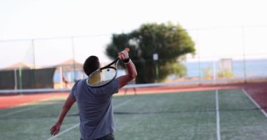 Tenis oyuncuları güneşli bir günde kortta maç yapıyorlar. Teniste sağlıklı yaşam tarzı ve spor eğitimi