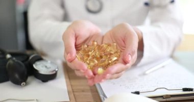 Doktorun ellerinde omega ya da vitamin hapı kapsülleri var. D vitamini yeni araştırma ve dozajlar