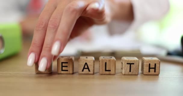 健康から繁栄への木製のキューブにメッセージをオンにします 医療と持続可能な金融の未来 — ストック動画