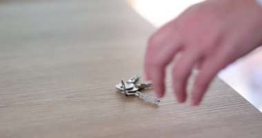 Kadın eli masadan anahtarları alır. Kiralık konutlar ve ev güvenliği