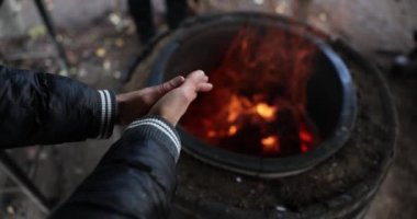 Evsiz ellerin yakını kendini ateşle ısıtıyor. Yoksulluk kavramı insanın sıcaklığı ya da kendini ateşle ısıtan bir turist.