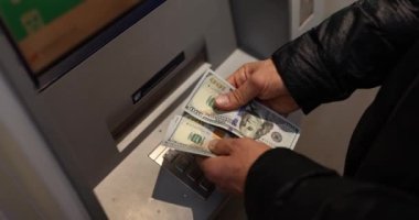 Adam ATM 'den çekilen paraları sayıyor. 24 saat hizmet. Nakit çekilmesi ve bankacılık işlemleri