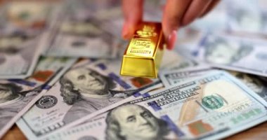 El, 1 dolarlık banknotlara altın külçeler serer. Değerli metallere yatırım yapan para değişimi konsepti