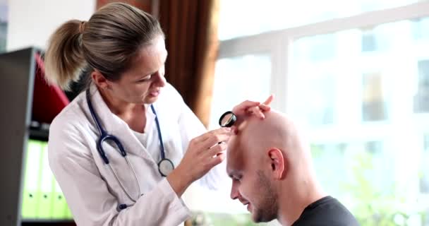 Tricologo Con Lente Ingrandimento Esamina Paziente Calvo Con Alopecia Clinica — Video Stock