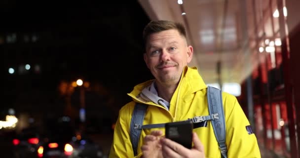若い幸せな男がスマートフォンを保持し こんにちは手を振るときに会う 観光ブロガーが市内で会う — ストック動画