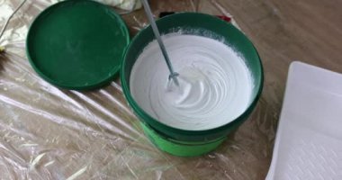 Tamirci plastik kovada boyayı karıştırırken mikser 4K yavaş çekim kullanır. İç tasarım boyama işi konsepti