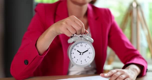 目覚まし時計を持っているビジネスマンの女性と時間に注意を親指 時間管理と締め切り — ストック動画