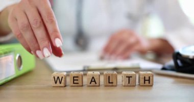 Wooden blocks with word Health and Wealth and doctor hand. Concept of choosing priority in life and lifestyle