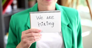 Businesswoman holding a paper with inscription we are hiring. job search business concept job advertisement