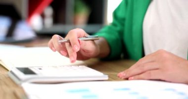 Hands of a business woman using calculator considers maths financial statistics in office. Taxation of accounting and analytical research