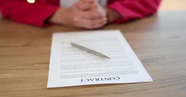 Business woman sits at office desk and waits to sign contract. Business agreement loan and lease or partnership