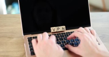 Wooden cubes with inscription vpn and hands on keyboard. Free VPN proxy anonymity