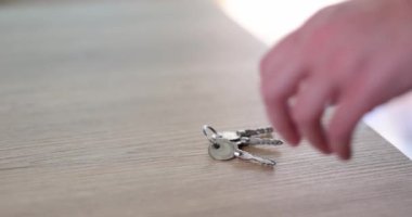 Woman hand takes keys from table. closeup. Rental and home security