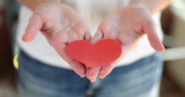 Woman hands holding red paper hearts. Valentine day concept of love and volunteering