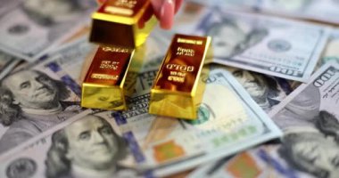 Gold bars on 100 new US dollars banknotes. Business concept of finance and money investment in gold