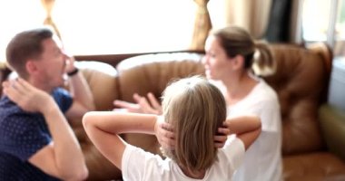 Parents scream quarrel child plugs ears at home. Family quarrels stress and divorce
