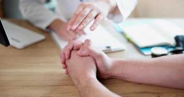 Doctor and patient hold hands for psychological support. Charity project and volunteering