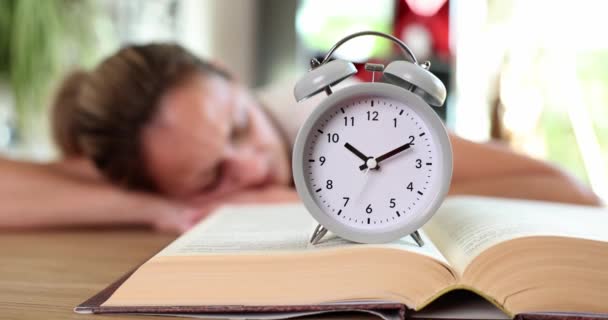 本や女性の背景で寝て目覚まし時計 動機の学習と喪失の教育時間概念 — ストック動画