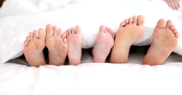 家庭腿在床上 父母和孩子 家庭舒适的睡眠卧室或旅馆 — 图库视频影像