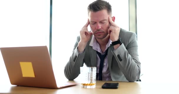 アルコール中毒の頭痛と片頭痛の若い従業員がオフィスに座っています 事業の破綻ストレスと問題 — ストック動画