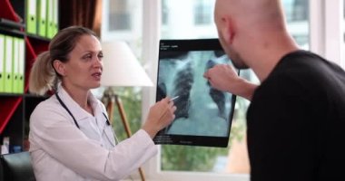 Therapist doctor explains x-ray of lungs of patient in hospital. Inflammation of lungs pneumonia and cough