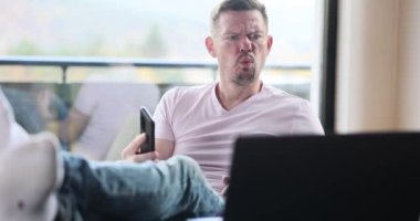 Crazy worker loses his temper screaming loudly about computer problems or virus attack. Angry young man screaming about laptop broken or data lost while working