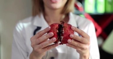 Nutritionist woman holding pomegranate and health benefits and healthy eating.Doctor recommends fresh fruits and healthy food and diet