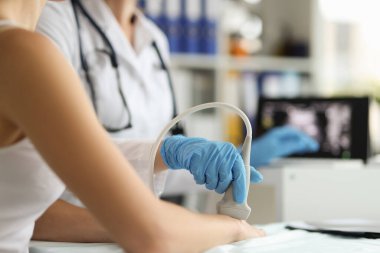 Doctor makes ultrasound of hand wrist in clinic. Ultrasound of vessels of upper extremities concept