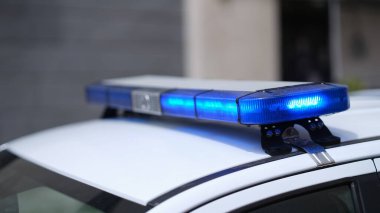 Closeup of blue lights on roof of police car. Flashing beacons of police car and arrest of criminal