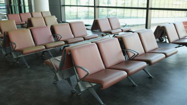Departure hall at airport with leather seats in row. Interior design airport station concept