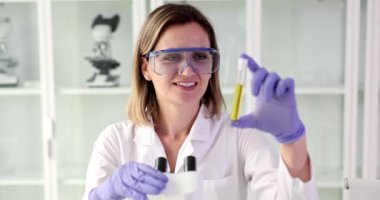 Scientist conducts laboratory testing of transparent toxic poisonous liquid in test tube. Collecting chemical data and analyzing urine or oil