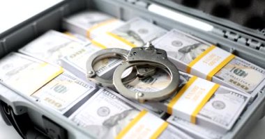 Handcuffs on one hundred dollar bills in case. Power and bribery and criminal ransom