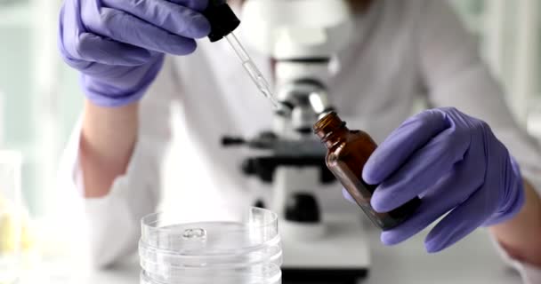 Scientist Chemist Drips Cosmetic Oil Pipette Jar Background Microscope Closeup — Video Stock