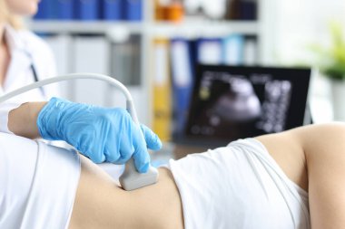 Doctor examines patient with prolapse of left kidney and spleen using ultrasound probe. Ultrasound diagnostics of soft tissues and organs concept