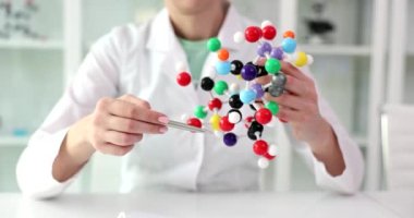 Woman scientist holds model of molecular compounds in hands. Study of human genome and conceptual scientific chemical innovation