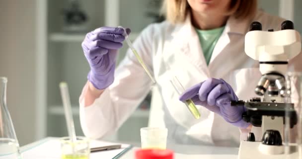 化学者は化学実験室の密室でディスペンサーから豆袋に油を滴下します 化学組成及び石油製品の研究 — ストック動画