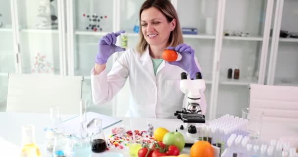 美丽的女科学家在实验室里拿着橘子和药丸 水果或维生素对健康的好处或危害 — 图库视频影像