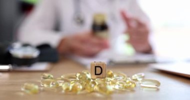 Masanın üzerinde yakın plan D vitamini kapsülleri var. Hastalıkların önlenmesi, bağışıklığın güçlendirilmesi