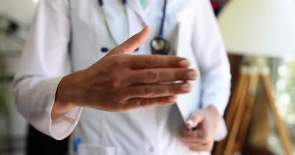 这个女人伸出手来握手 只是肤浅地专注了一下 诊所里的问候 友好的医护人员 — 图库视频影像