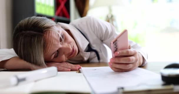 Egy Fáradt Doktornő Ránéz Egy Okostelefonra Közelről Lassítva Krónikus Fáradtság — Stock videók