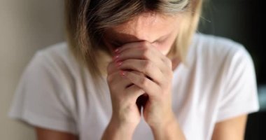 Kadın başını eğdi ve ellerini yüzüne koydu, yakın çekim, yavaş çekim. Tanrı için duayı kabul et.