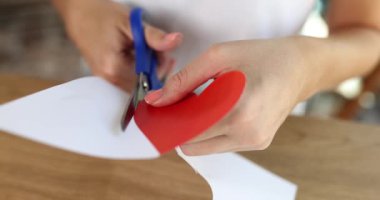 Kadınların elleri, kalplerinin makasıyla kağıttan kesilir. Yakın plan, yavaş çekim. Kartpostalı destekle, aşkım.