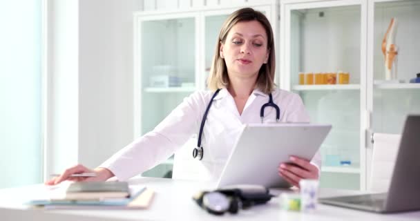 Displeased Female Doctor Examining Medical Documents Clinic Movie Slow Motion — Stockvideo