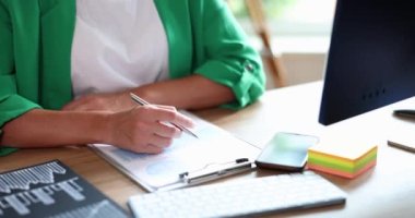 Businesswoman in green suit sitting at table and crossing her arms closeup 4k movie slow motion. Business administration concept 