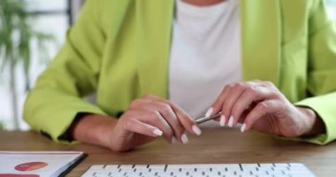 Businesswoman nervousing and twisting iron ballpoint pen in hands closeup 4k movie slow motion. Making important business decisions concept 