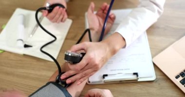 Doctor therapist measuring blood pressure to patient in clinic using tonometer closeup 4k movie slow motion. Diagnosis and treatment of arterial hypertension concept 