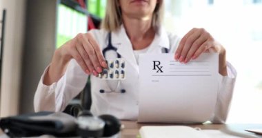Doctor holding form with prescription and blister of medicines in clinic closeup 4k movie slow motion. Prescription drug dispensing concept