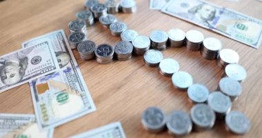 American dollar sign made of coins on background of paper bills 4k movie slow motion. Successful business concept 