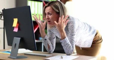 Woman manager looking at computer screen and grabbing her head 4k movie slow motion. Problems with partners online concept 