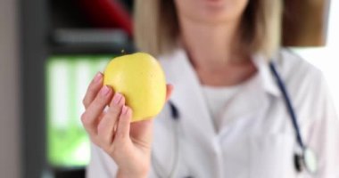 Woman nutritionist holding apple fruit in her hands closeup 4k movie slow motion. Healthy lifestyle proper nutrition concept 